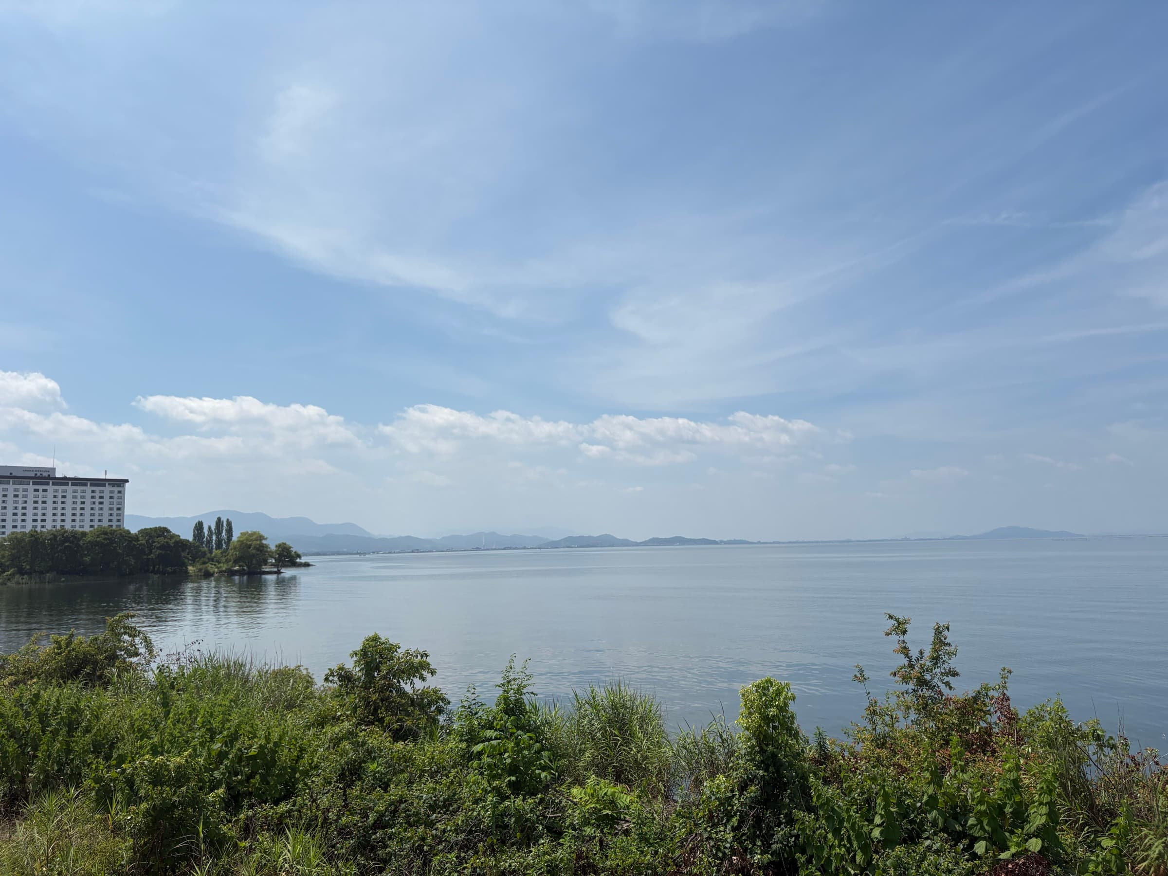 長浜の湖岸から望む琵琶湖。夏の空の下、穏やかな湖面が広がる
